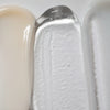 特写图片展示了 Solawaves LightBoost Wand Activating Serum 的质地：乳白色的米色、注入 LightBoost 技术的透明啫喱和光滑的浅灰色/白色乳霜。质地从乳状到啫喱状不等，每种质地都呈现出光泽感。
